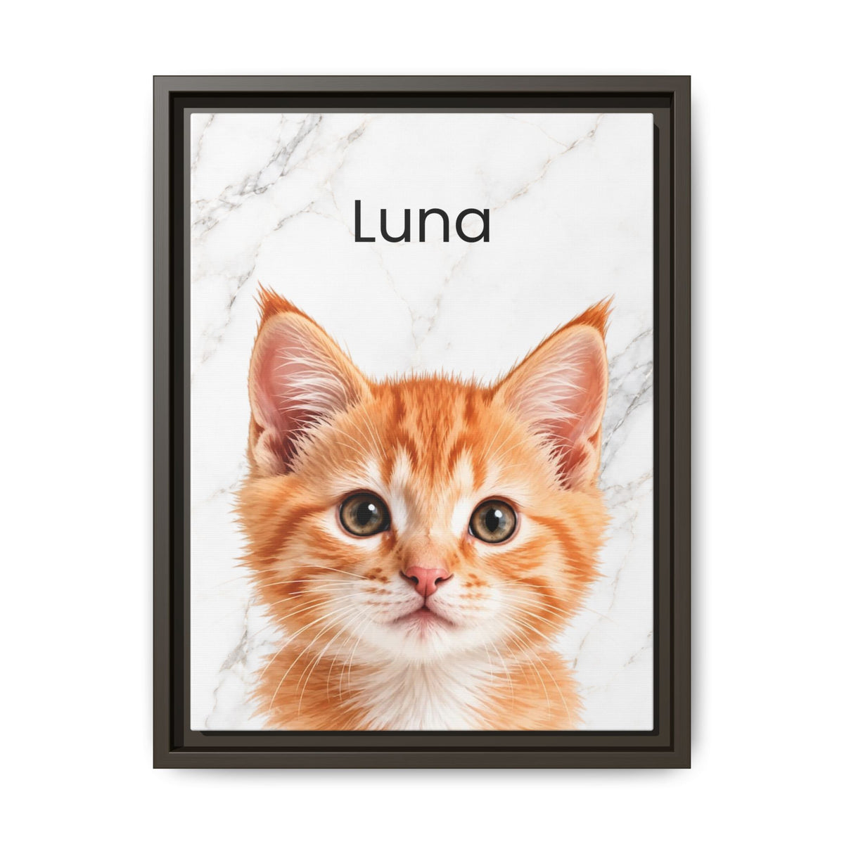 A framed custom pet portrait featuring a close-up photo of an orange tabby kitten on a white marble background with the name 'Luna' printed in black text, enclosed in a dark frame.