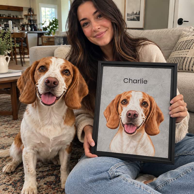 A woman sitting on a couch in a living room holds a framed custom pet portrait of a brown and white beagle dog named 'Charlie'. A real beagle dog sits beside her on a patterned rug, smiling.